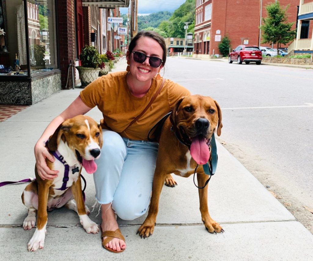 Camden Lambert on the sidewalk with her two dogs.